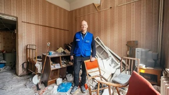 Mark Mullan, der das LWB-Team in der Ukraine leitet, inmitten einer Wohnung, die bei einem Angriff verwüstet wurde. Der LWB setzt Wohnungen in Charkiw wieder instand. Foto: LWB/A. Nazarenko