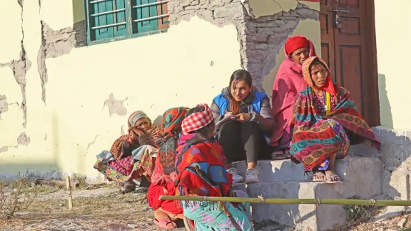 Die Mütter einiger Schulkinder sprechen vor dem beschädigten Schulgebäude mit einer LWB-Mitarbeiterin. Foto: LWB Nepal