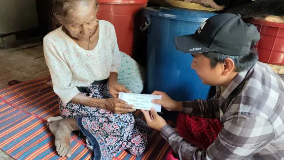 Eine Begünstigte der Arbeit in Myanmar erhält Bargeld für den Kauf von Lebensmitteln. Foto: NAG