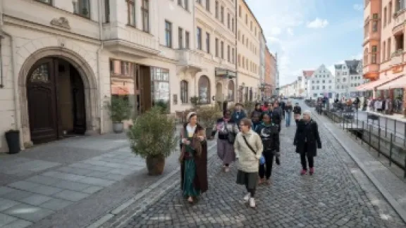Die Teilnehmenden bei einer Führung durch „Wittenberg zur Zeit Martin Luthers“. Stadtführerin Katja Koehler schlüpft dabei in die Rolle von Martin Luthers Ehefrau, Katharina von Bora. Foto: LWB/Albin Hillert