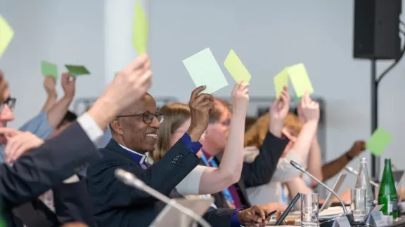LWB-Ratsmitglieder heben am letzten Tag der Ratstagung vom 11. bis 15. Juni in der Nähe von Genf, Schweiz, in einer Abstimmung grüne Karten, um ihre Zustimmung zu einer Empfehlung zu signalisieren. Foto: LWB/Albin Hillert