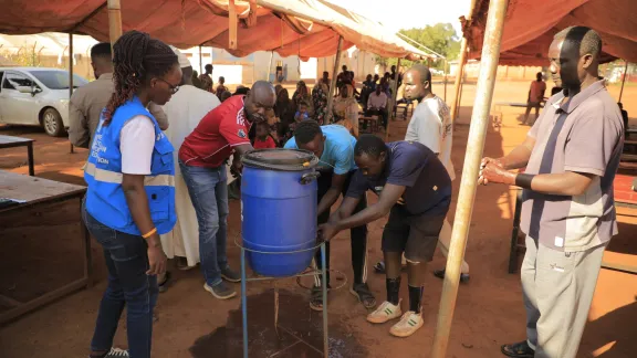 Neu angekommenen Geflüchteten im Aufnahmezentrum Kiryandongo wird gezeigt, wie man sich richtig die Hände wäscht. Dies soll gute Hygienepraktiken fördern und die Ausbreitung von Krankheiten verhindern. Foto: LWB Uganda