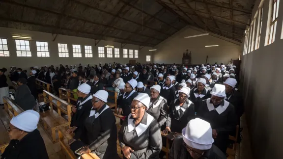 Gottesdienstbesucherinnen und -besucher – darunter viele Mitglieder des ELCSA-Frauengebetsbundes – singen und beten in den Kirchenbänken während des Sonntagsgottesdienstes in der Gemeinde Ephangweni. Foto: LWB/Albin Hillert