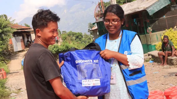 Viele Familien sind dankbar für die Hygienesets für Frauen und Mädchen. Hier übergibt eine Mitarbeiterin von LWB Nepal eine Tasche mit Hygiene- und Sanitärartikeln. Foto: LWB Nepal
