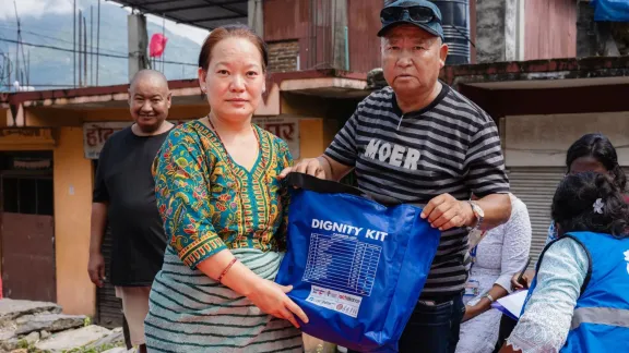 Der gewählte Gemeindevertreter Lal Bahadur Lama übergibt einer Einwohnerin von Uttargaya im Distrikt Rasuwa ein Hygieneset. Foto: LWB Nepal
